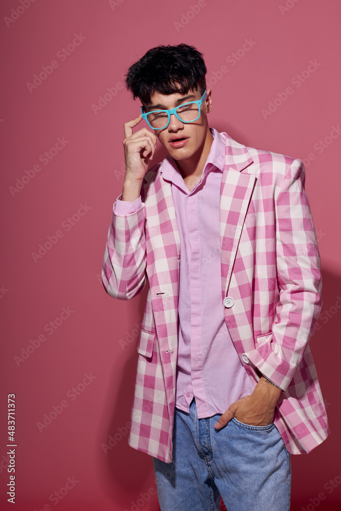 A young man fashionable glasses pink blazer posing studio pink background unaltered