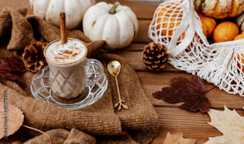 Cup of Pumpkin Spice Latte and Fall Decor from fresh  pumpkins. Traditional Coffee Drink for Autumn Holidays  cozy  hygge  comfortable