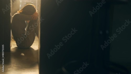 Silhouette of Loneliness Asian woman sitting on the floor with hugging herself. Depressed female living alone in the dark room and think of life problems. People mental health and social issue concept