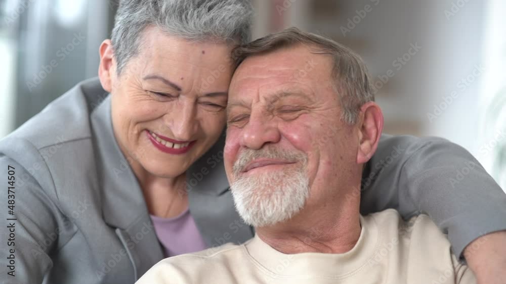 Tenderness and love in the relationship of an elderly gray-haired couple. Woman and man lean their foreheads against each other, portrait of an elderly family