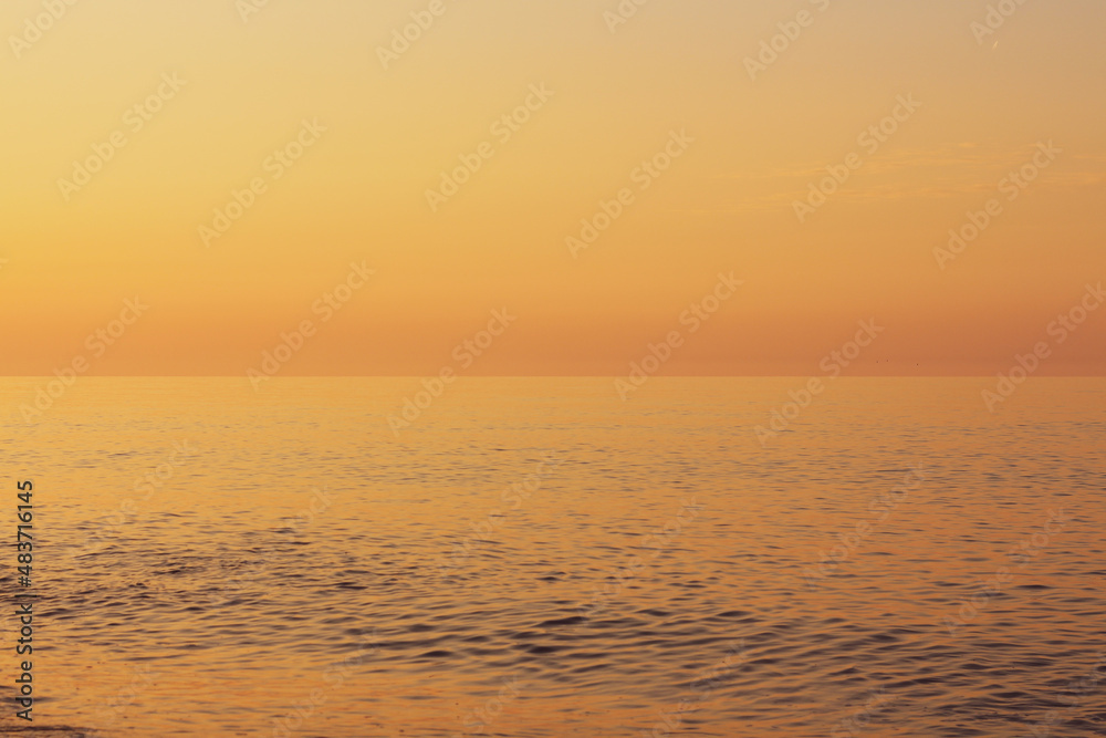 Fototapeta premium Beautiful sunset on the rocky beach . Soft peaceful water composition