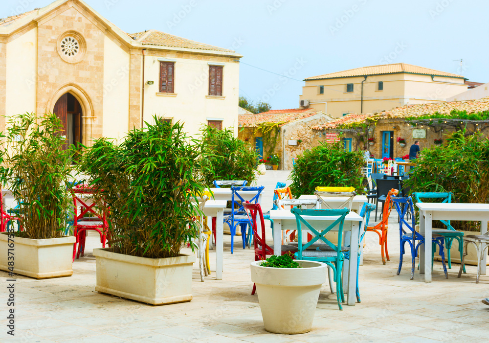 Obraz premium Empty terrace restaurant in Sicily on street – outside coffee and restaurant terrace - Outdoor patio chair and table in café restaurant – street café terrace in italy