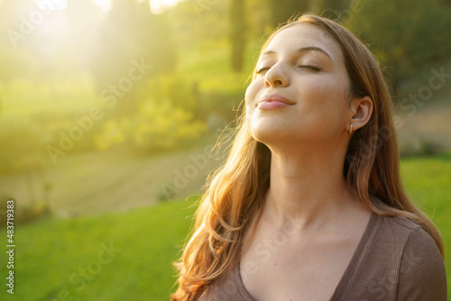 Close-up woman at sunset relaxing breathing fresh air photo