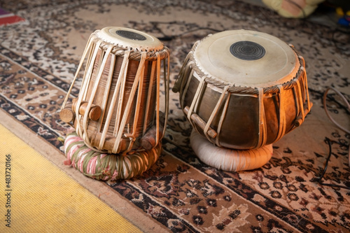 a small child trying to learning to play the tabla .