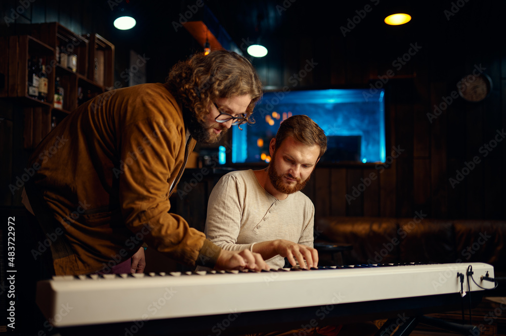 Teacher and student playing synthesizer during lesson