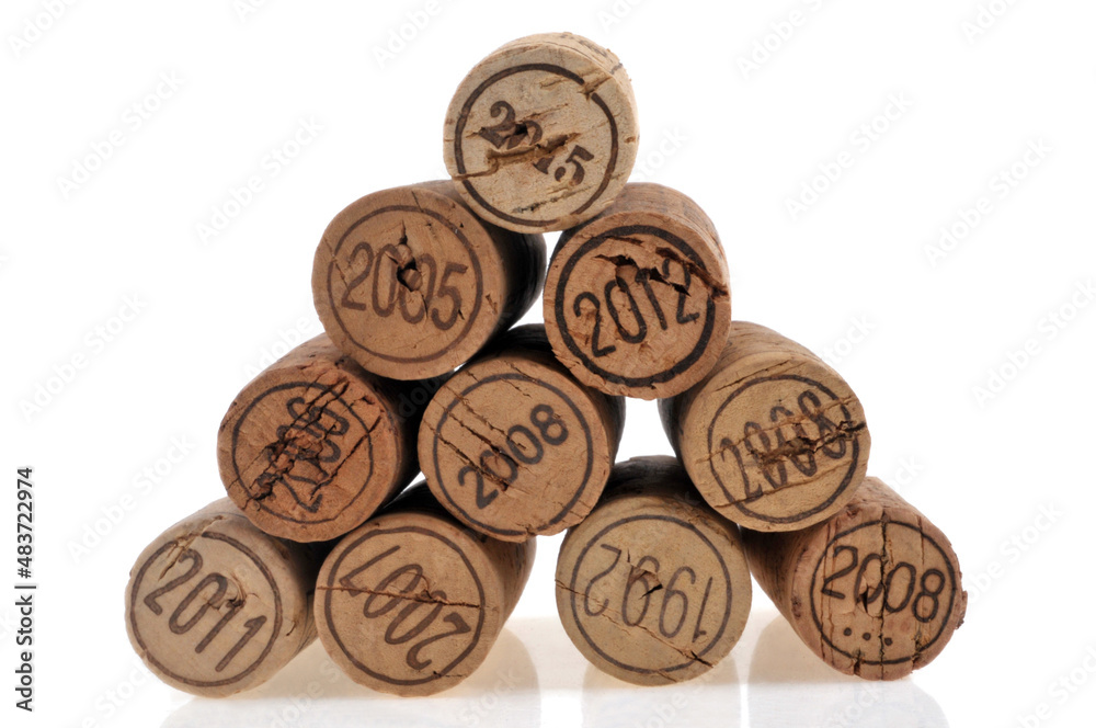 Corks from French wine cork bottles of different years stacked on white