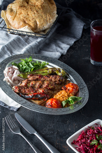 turkish adana kebab, salad, lavash, buttermilk, on the dark bacground