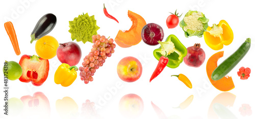 Falling colorful vegetables and fruits with light reflection isolated on white