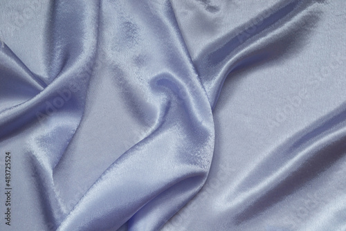 Satin, shiny fabric is folded into graceful folds. Grey-blue color.