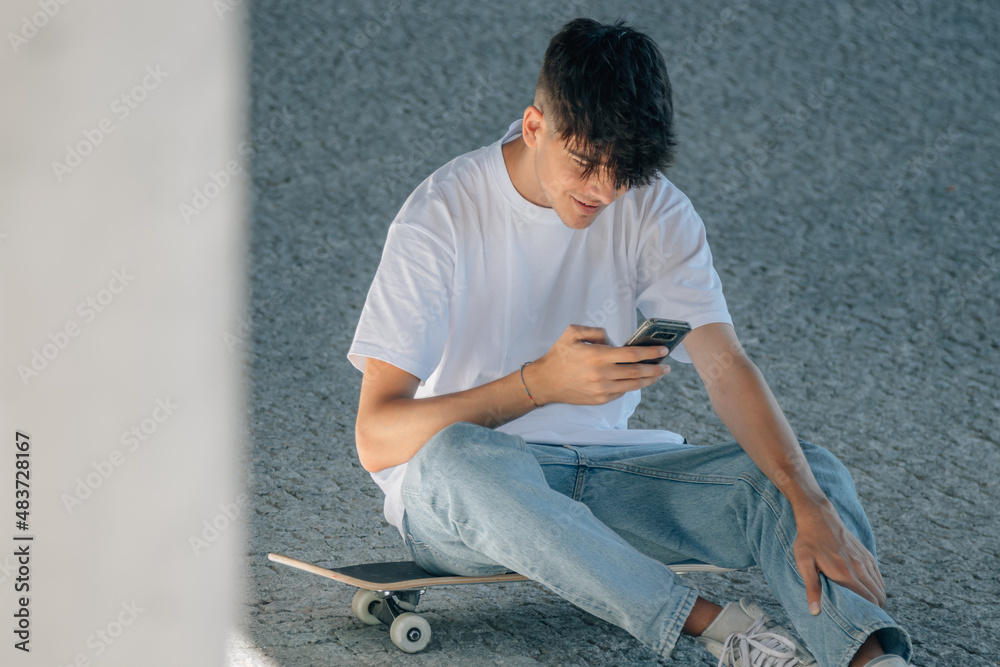 young millennial with mobile phone and skateboard young millennial with mobile phone and skateboard