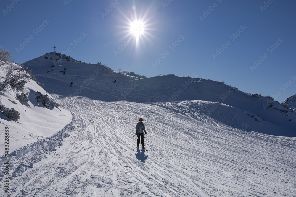 skier rushes down a snowy slope