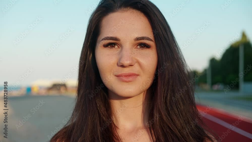 Close up one woman feminist face looking at camera standing near beach. People feminism face portrait closeup. Confident serious. Adult young confident girl rebel. Close up one woman feminist face looking at camera standing near beach. People feminism face portrait closeup. Confident serious. Adult young confident girl rebel.