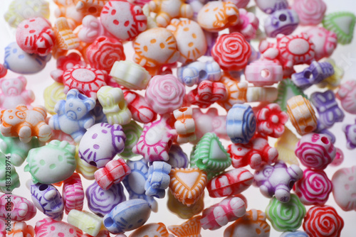 Pile of cute colorful ceramic beads on white background, closeup