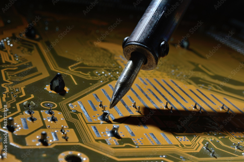 a heated soldering iron solders a small contact on the chip