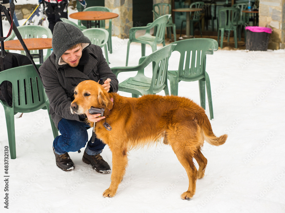 Male blogger shooting video with his dog for a blog in winter outdoors. Pet owner and travel blogging concept. Male blogger shooting video with his dog for a blog in winter outdoors. Pet owner and travel blogging concept.