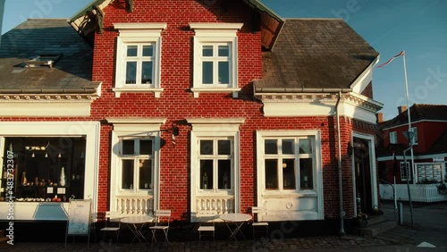 Beautiful red old building in the old town on the island of fanø. Danish flag waving in the wind. Genaral Shop Store photo