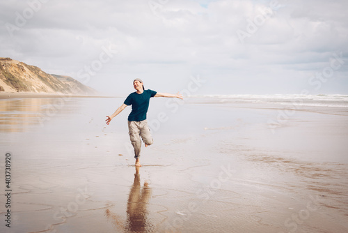 Young man with wanderlust enjoying his sabbatical holiday on the idyllic beach of New Zealand photo