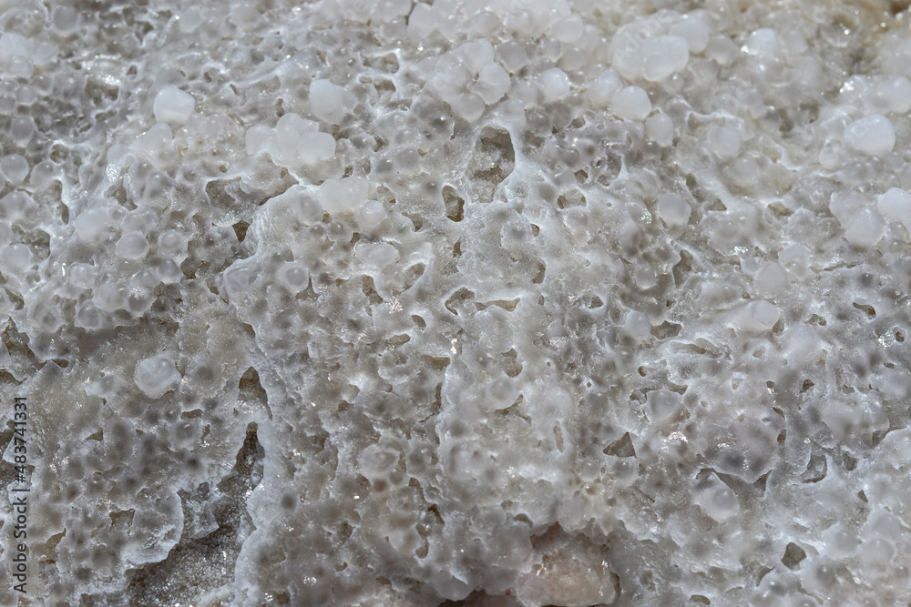 Obraz premium Close up of salt background. Natural salt. Dead Sea salt mineral natural formations. Salt crystals from Dead sea. View of Dead Sea coastline. Texture of Dead sea. Salty seashore rocks