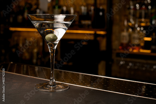 Front photo of crystal clear cocktail with olive into martini glass