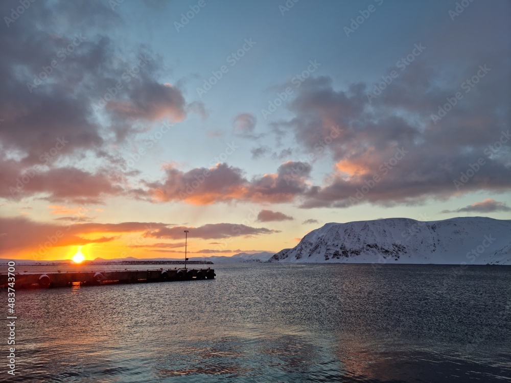 sunset over the sea and pier in wintertime