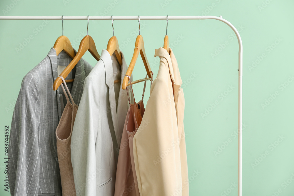 Obraz premium Rack with clean female clothes on green background, closeup
