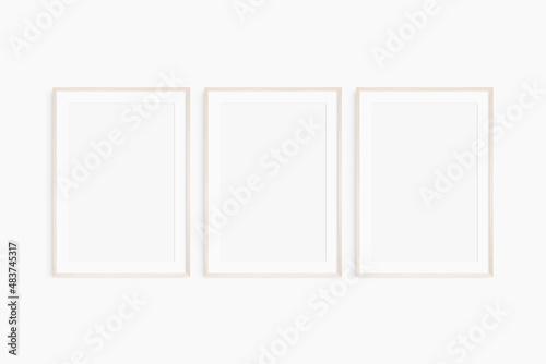 Frame mockup 5x7, 50x70, A4, A3, A2, A1. Set of three thin light wood frames. Gallery wall mockup, set of 3 frames. Clean, modern, minimalist, bright. Portrait. Vertical. Mat opening 2:3.