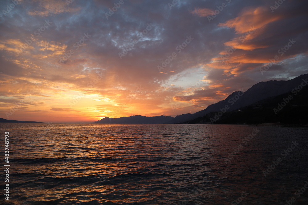Sunset in the sea. Picturesque cloudy sky and sea at sunset in summer evening. Croatia, Dalmatia, Makarska
