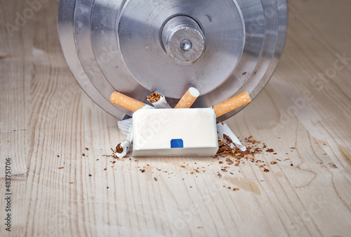 Fotografi dumbbell smash pack of cigarettes breaking them