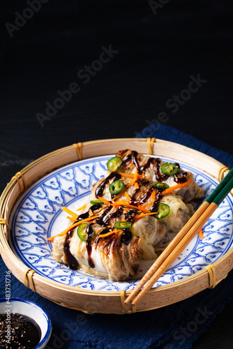 Food concept Homemade baked Chinese cabbage rolls in asian style ceramic plate with black slate stone background with copy space