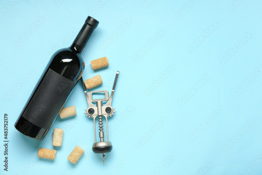 Bottle of wine, corks and opener on blue background Bottle of wine, corks and opener on blue background
