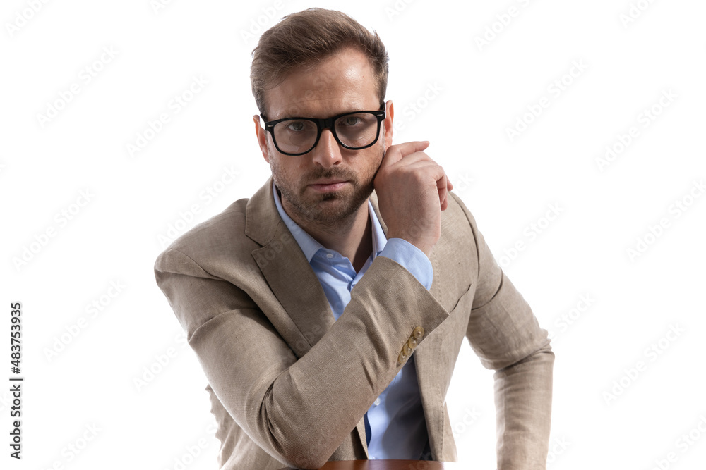 handsome businessman posing with one hand on a chair handsome businessman posing with one hand on a chair