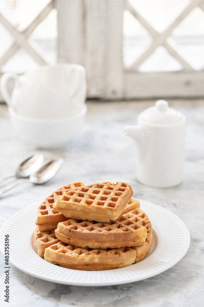 Waffles with yogurt on a white porcelain plate with black geyser coffee maker on the windowsill Waffles with yogurt on a white porcelain plate with black geyser coffee maker on the windowsill