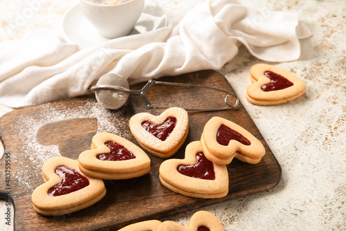 Board with tasty cookies for Valentine's Day celebration on light background