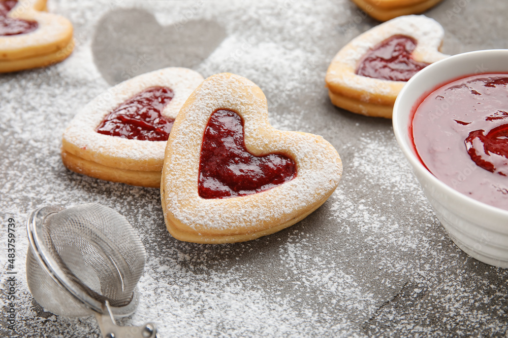 Tasty cookies and jam for Valentine's Day celebration on grey background, closeup