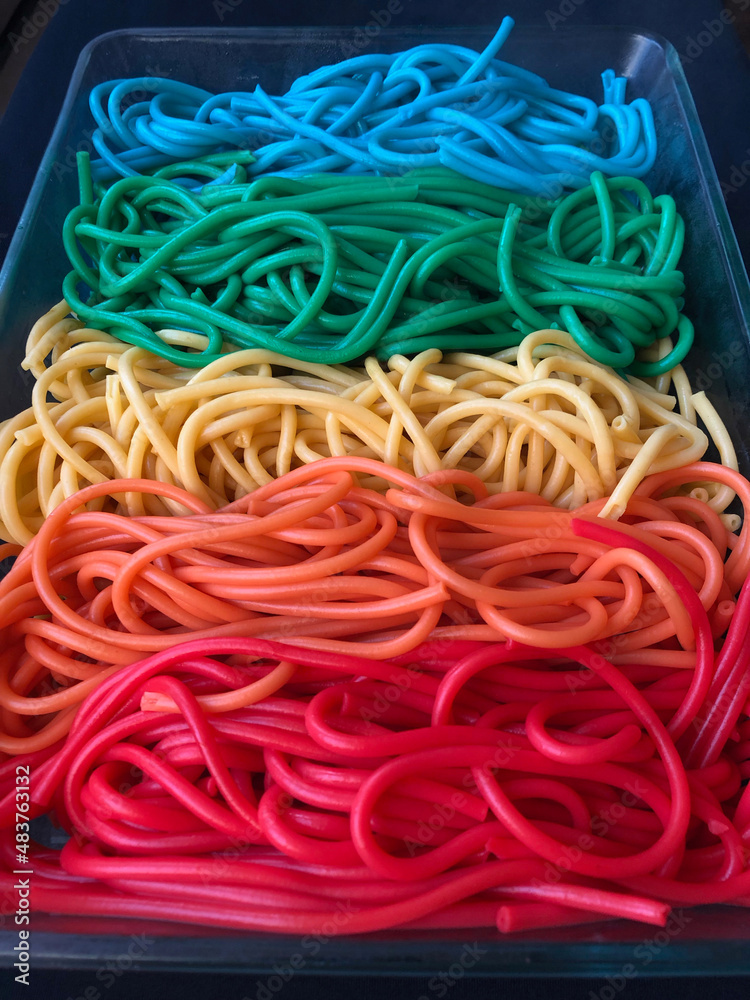 Long pan full of brightly colored spaghetti