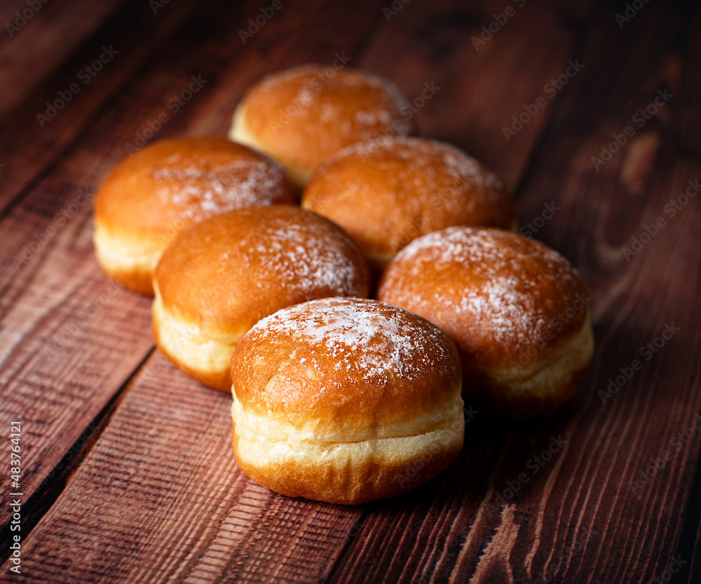 Pastry Perfection: Austria's Krapfen Paired with Germany's Cream-Laden Berliner Delights. On wooden background. Selective focus