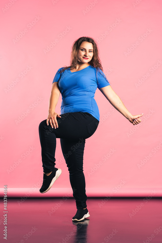 Happy plus size model in casual clothes on pink background Happy plus size model in casual clothes on pink background