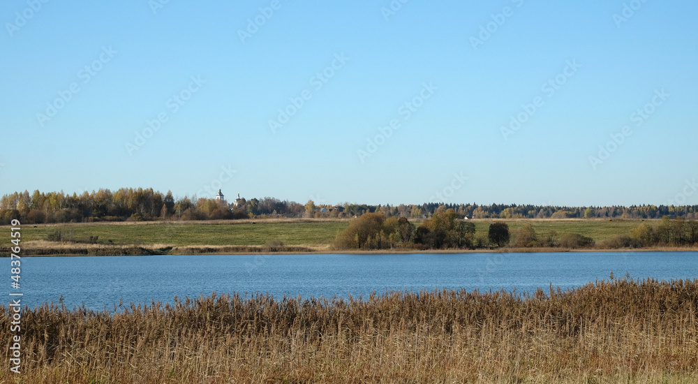 Calm quiet blue rural river with panoramic view to other coast in the beginning of the autumn