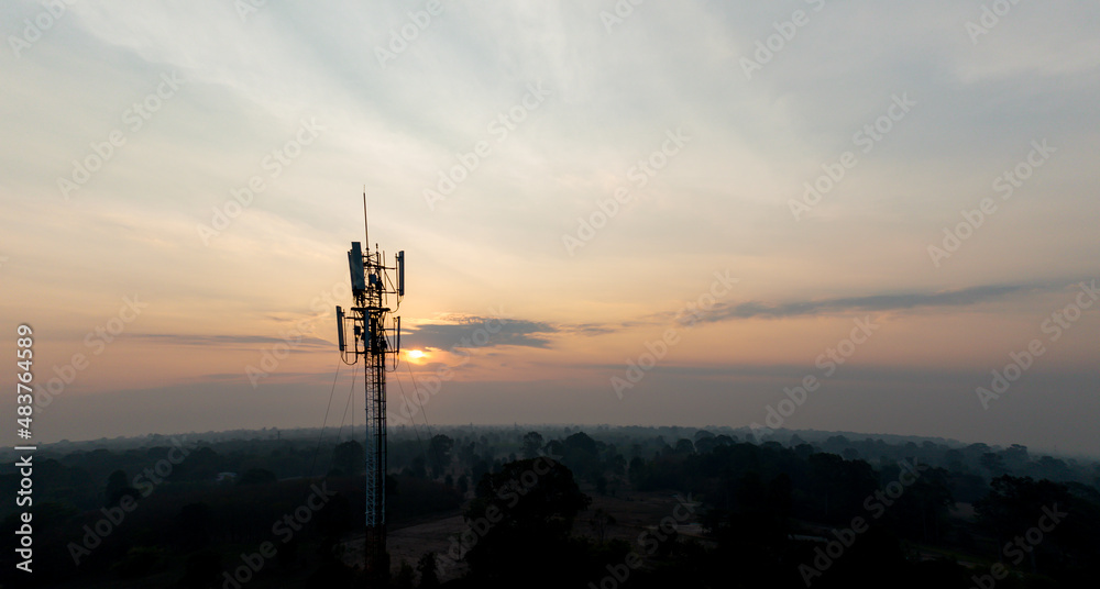 Telecommunication tower of 4G and 5G cellular. Macro Base Station. 5G radio network telecommunication equipment with radio modules and smart antennas mounted on a metal on cloulds sky background.
