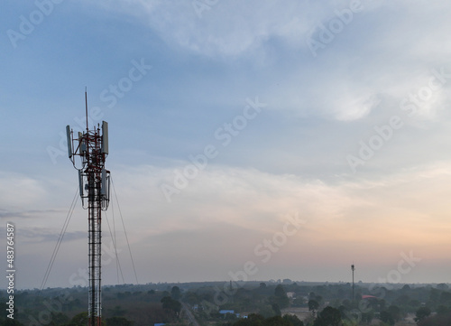 Telecommunication tower of 4G and 5G cellular. Macro Base Station. 5G radio network telecommunication equipment with radio modules and smart antennas mounted on a metal on cloulds sky background.