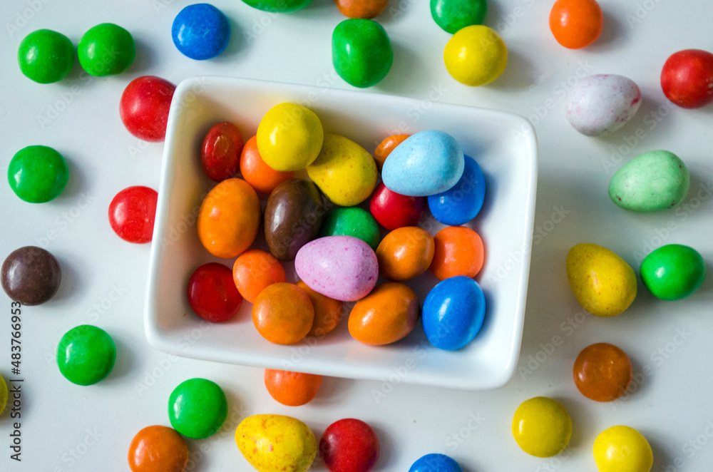 Close up of colorful chocolate buttons on a white background. Close up of colorful chocolate buttons on a white background.