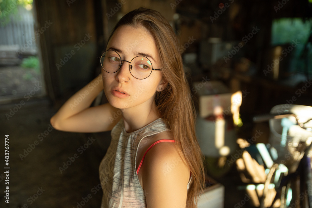 Beautiful young girl in round glasses pantry house in the country