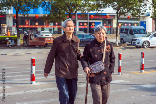 Obraz na płótnie ANQING, CHINA - MARCH 21: Senior Man and Woman walk crossing Street. A senior couple, 80 years old, helping each other, walk crossing the street on March 21, 2014 w salonie