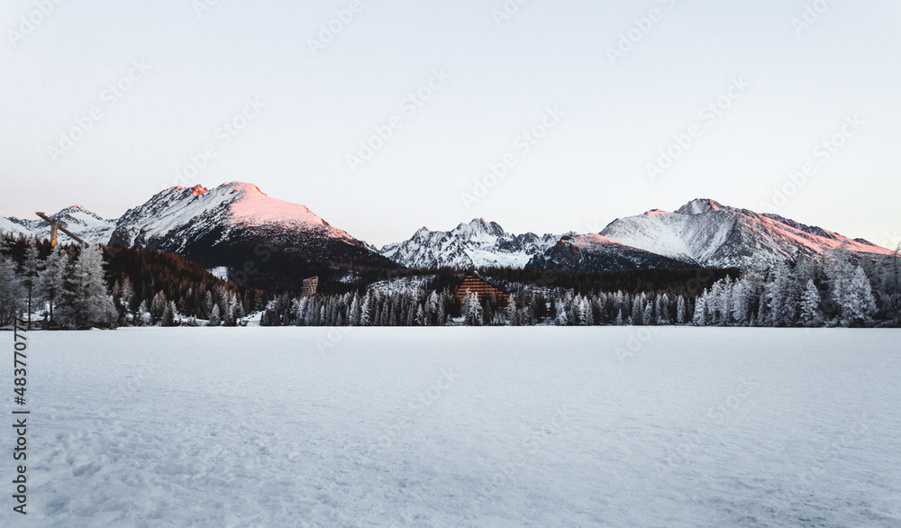 Landscape photo of frozen and snow covered Strba tarn (Strbske pleso) in winter time. Mountains in Slovakia with frozen lake on foreground in early morning sunrise. Landscape photo of frozen and snow covered Strba tarn (Strbske pleso) in winter time. Mountains in Slovakia with frozen lake on foreground in early morning sunrise.
