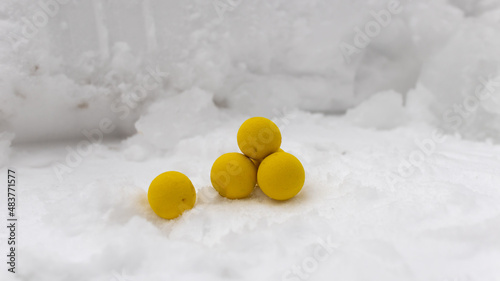 Yellow balls on a snowy background in winter. Close-up.