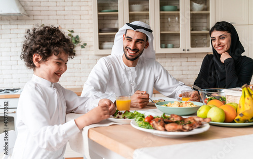 Photography happy family from arab united emirates eating together and celebrating the natio