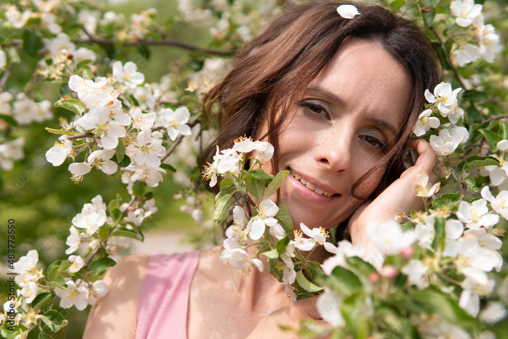 Fototapeta premium A woman near a blooming spring tree. Romantic happy mood.