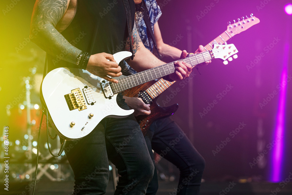 Obraz premium Two guitarists performing at a live concert.