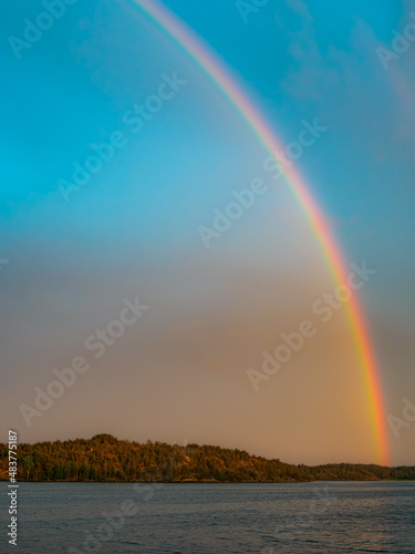 Island in the Baltic sea with rainbow on blue sky. background in vertical frame, beautiful nature background concept
