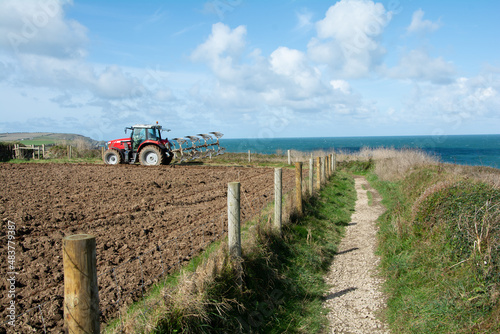 October 2019 - A farmer ploughs his field on a coastal farm at Trevose Head in Cornwall, UK